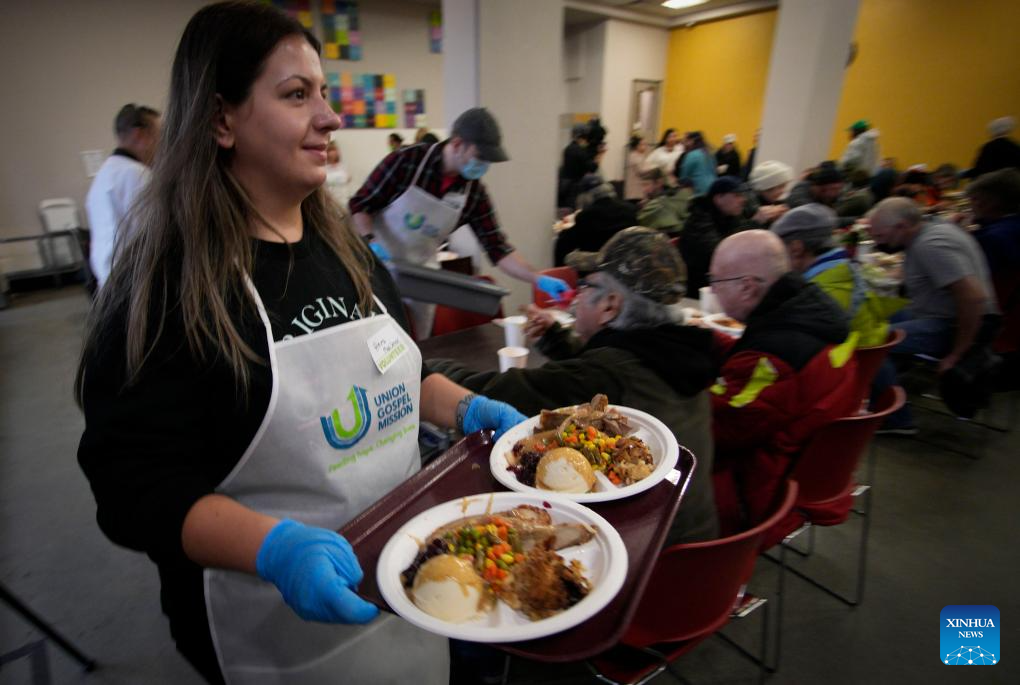 Volunteers serve food during annual Christmas dinner at UGM in Canada