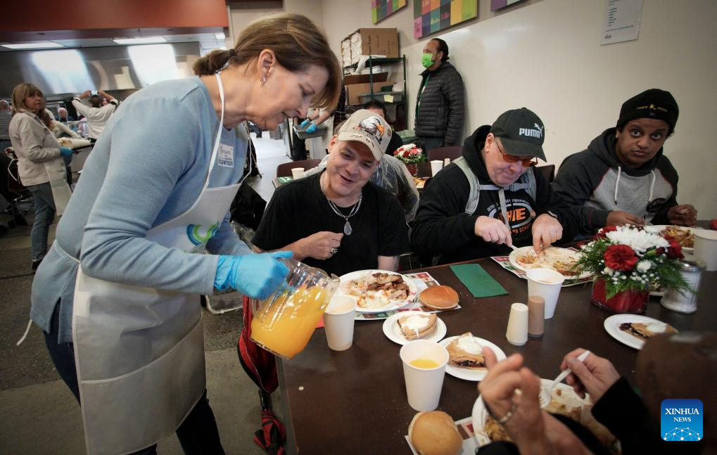 Volunteers serve food during annual Christmas dinner at UGM in Canada