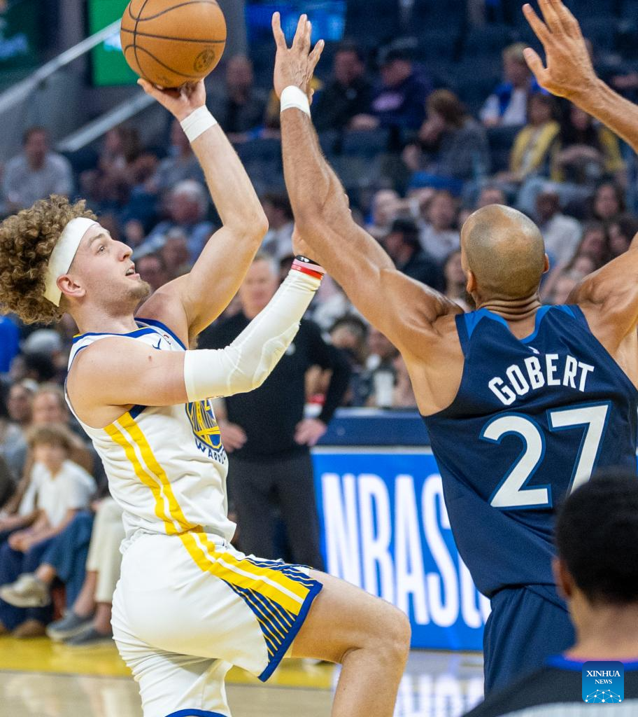 Golden State Warriors' Brandin Podziemski (L) shoots during the 2025-2026 NBA regular season basketball game between Minnesota Timberwolves and Golden State Warriors in San Francisco, the United States, March 13, 2026. (Photo by Dong Xudong/Xinhua)