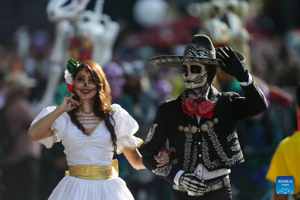 Personas participan en el desfile del Día de Muertos en Ciudad de México-Xinhua