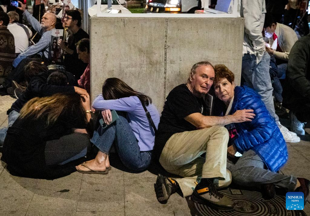 People take cover while air raid siren sounds in Tel Aviv, Israel