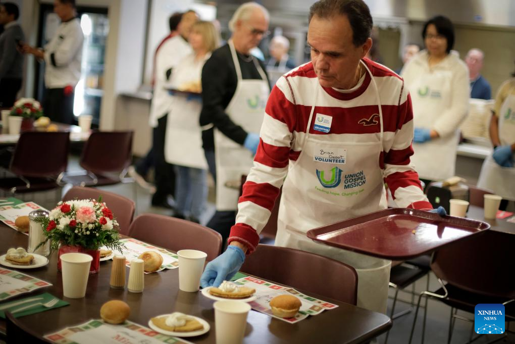 Volunteers serve food during annual Christmas dinner at UGM in Canada