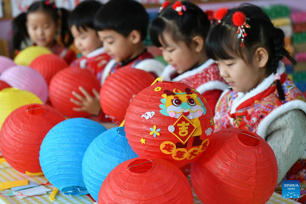 Crianças fazendo lanternas para o Ano Novo Lunar Chinês em um jardim de infância na China.