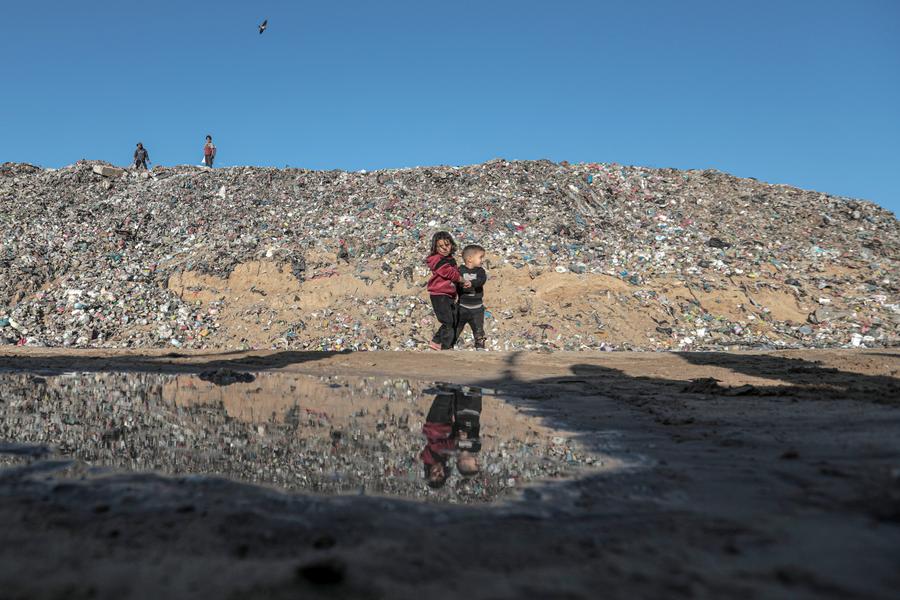 Palestinian children in front of a garbage dump in the ‍al-Nuseirat refugee camp