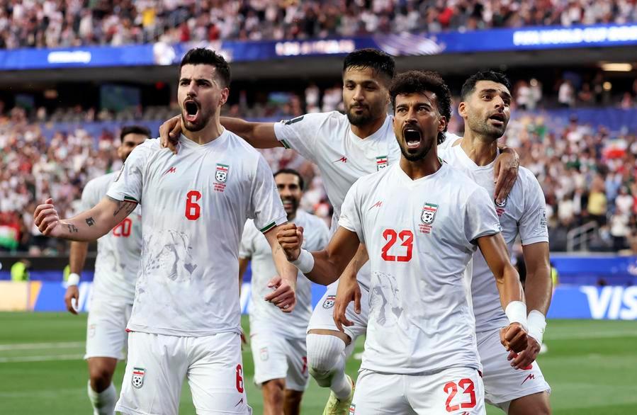 Ramin Rezaeian merayakan gol