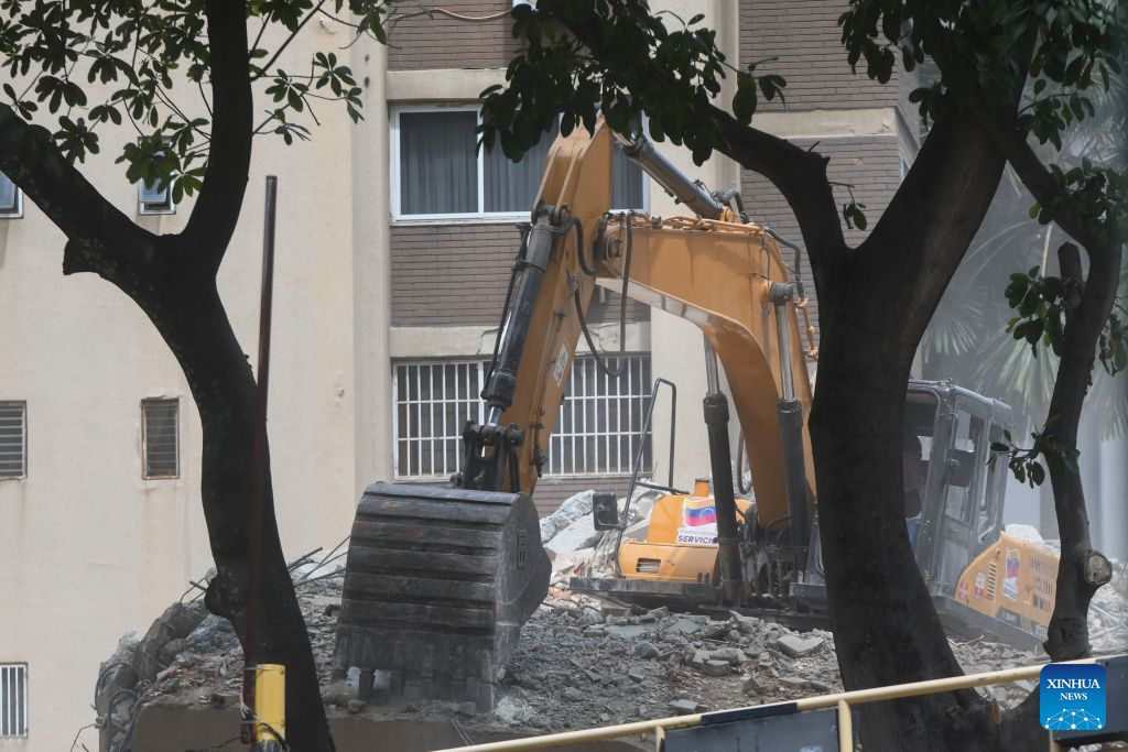 An excavator works on a collapsed building in Chacao, Venezuela, on June 28, 2026