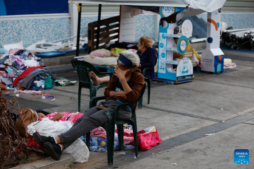 People stay near a collapsed building in La Guaira, La Guaira state, Venezuela, June 28, 2026
