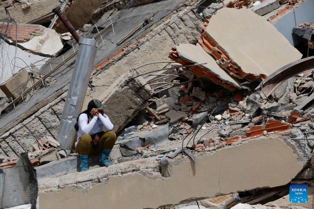 A woman sits on the rubble of a collapsed building in Caraballeda, La Guaira state, Venezuela, June 28, 2026