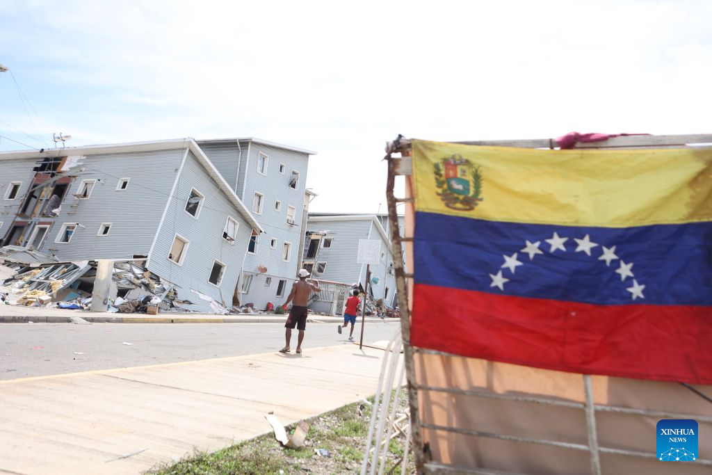 A Venezuelan national flag is seen in an area affected by earthquakes in Playa Grande, La Guaira state, Venezuela, June 28, 2026