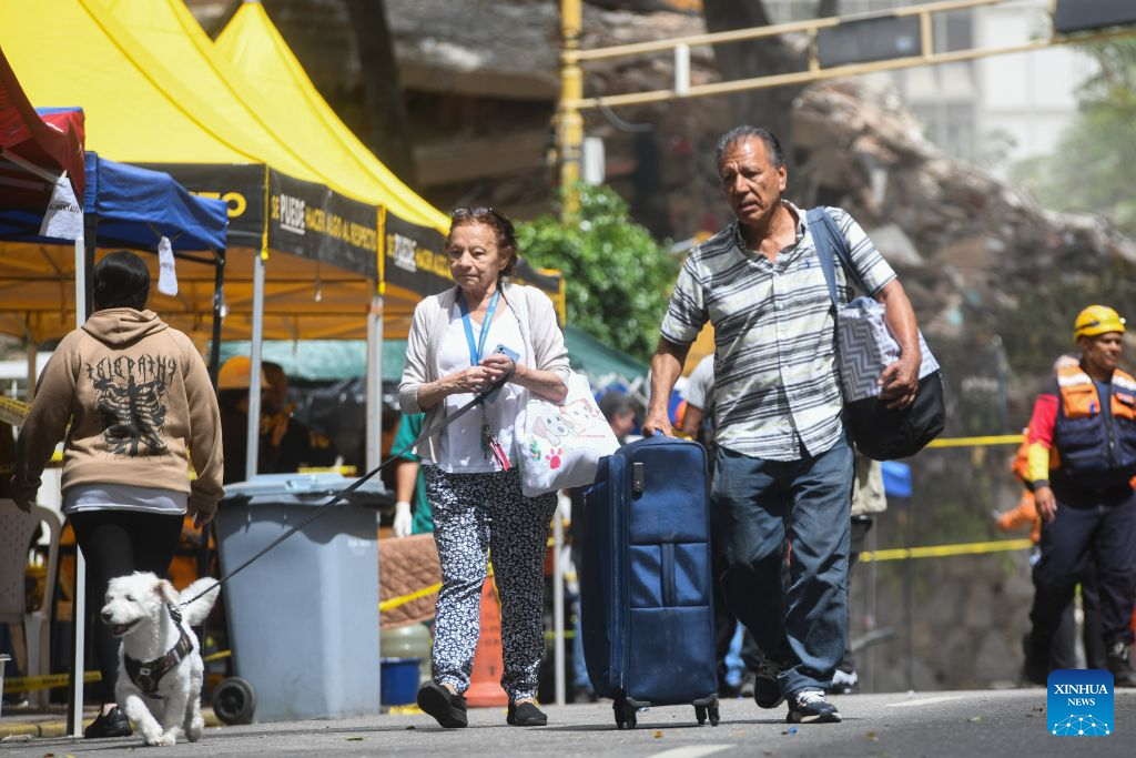 People retrieve their belongings from an area affected by earthquakes in Chacao, Venezuela, on June 28, 2026